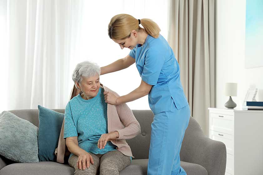 https://www.astongardens.com/wp-content/uploads/2022/08/nurse-covering-elderly-woman-with-blanket-indoors-assisting-senior-people.jpg